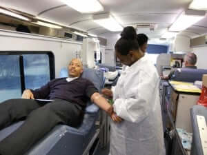 Arlance Jenkins rolls up his sleeve to donate blood.