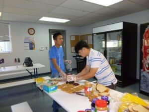 Binh Nguyen and Quang Vo making peanut butter and jelly sandwiches for the Presbyterian Night Shelter. | Fort Worth Philanthropy 2015
